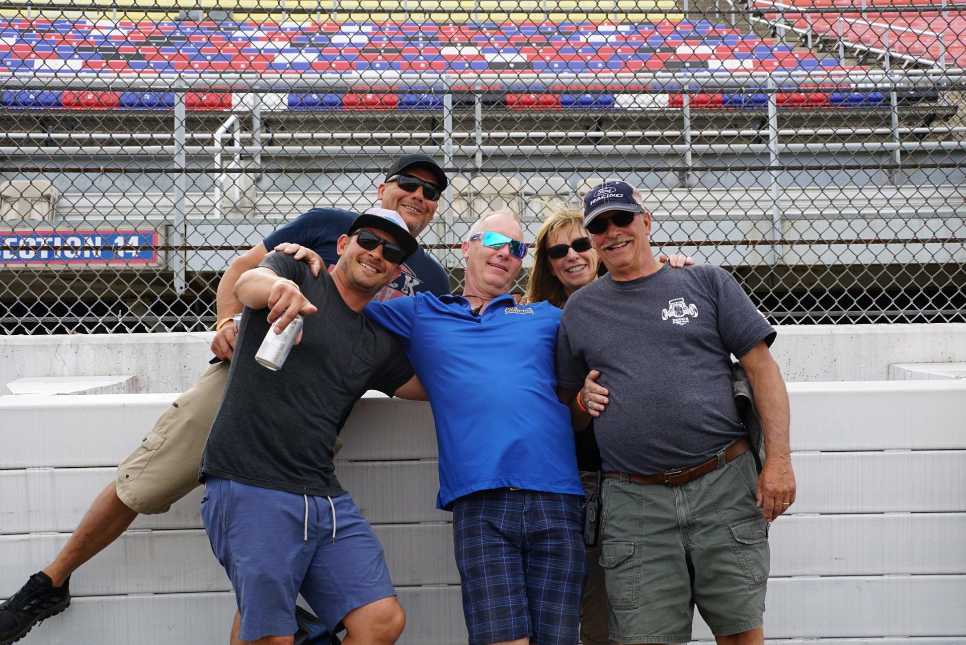 A group of people posing for a picture in front of a stadium