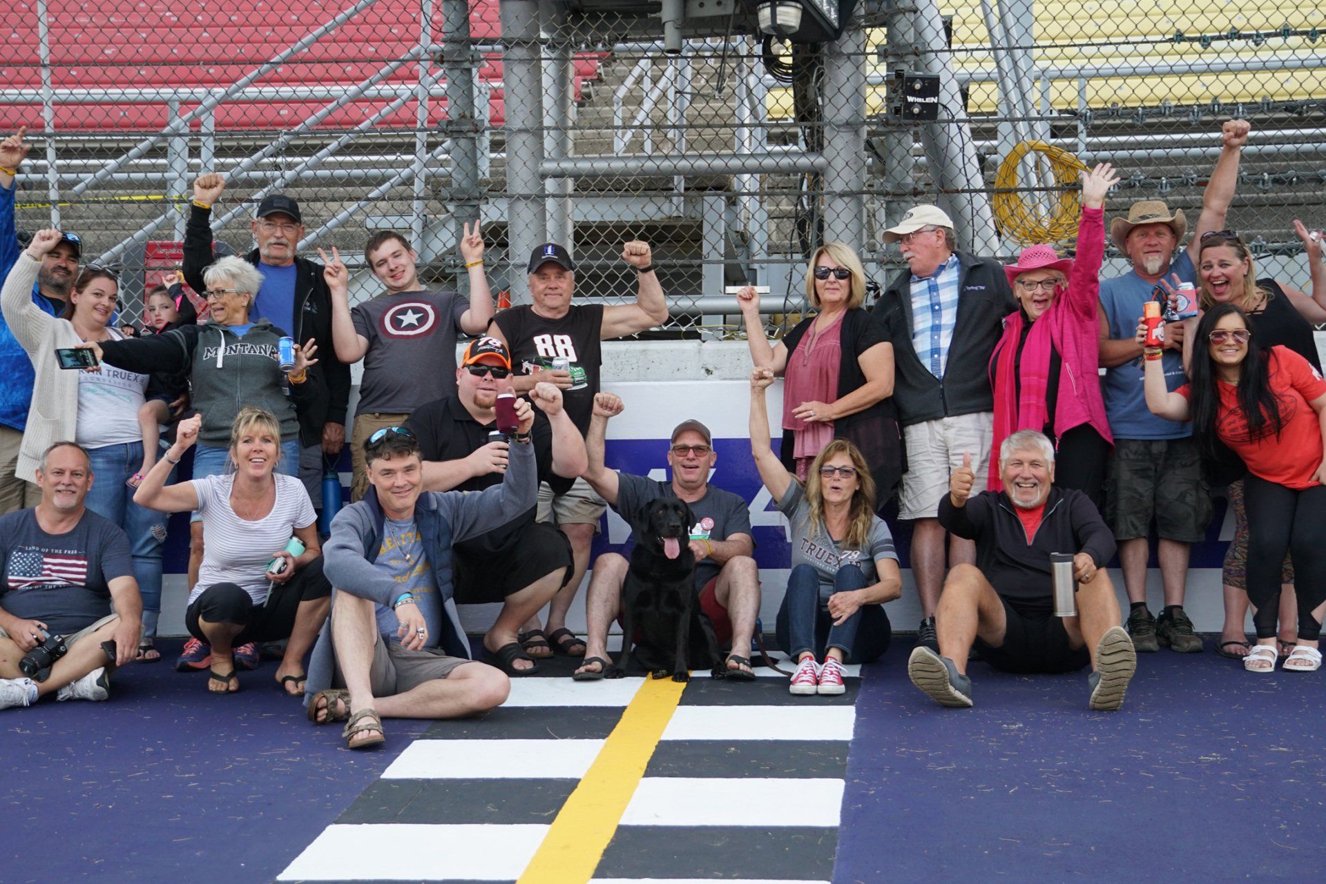 A group of people are posing for a picture in front of a stadium.