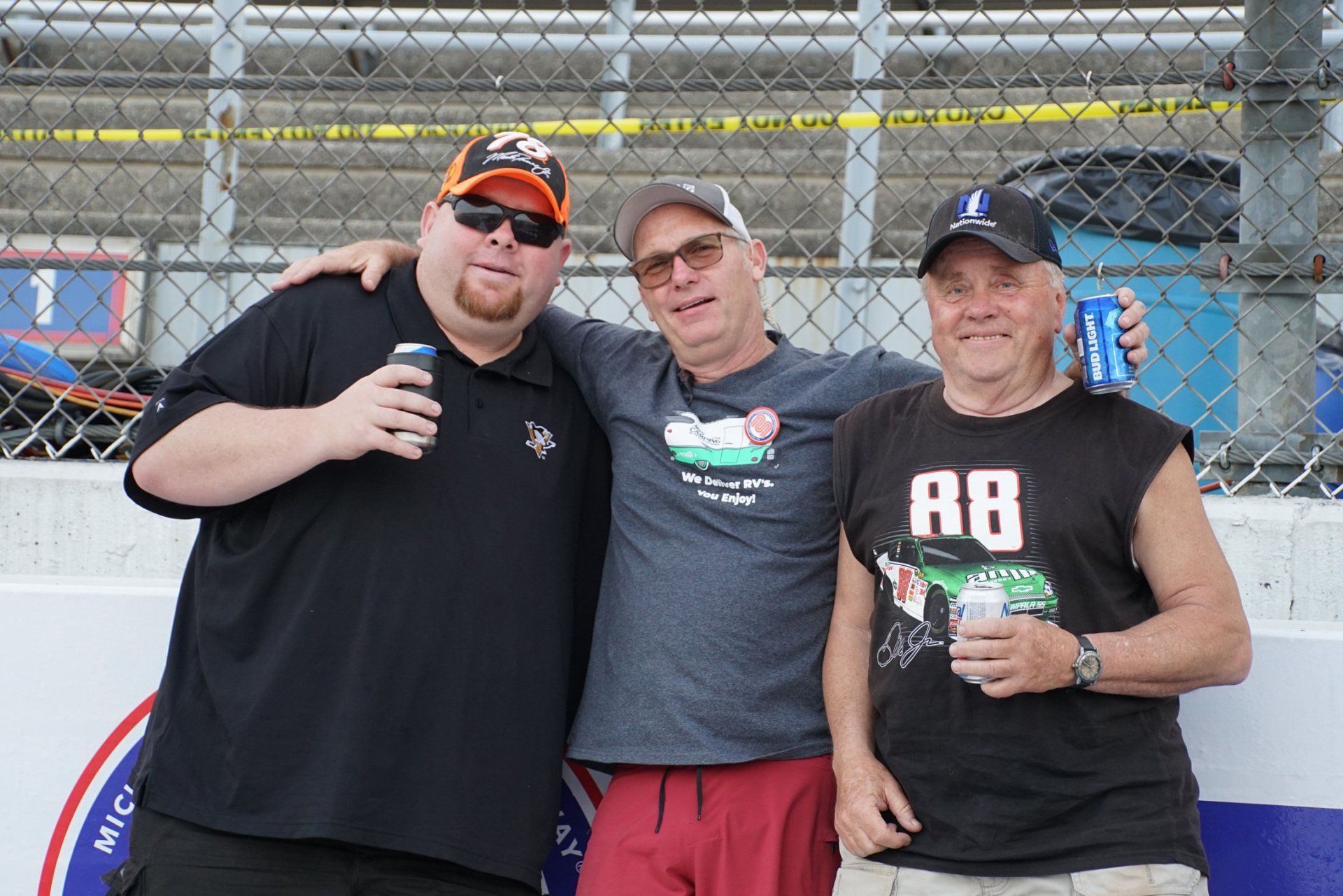 Three men posing for a picture with one wearing a shirt that says a8