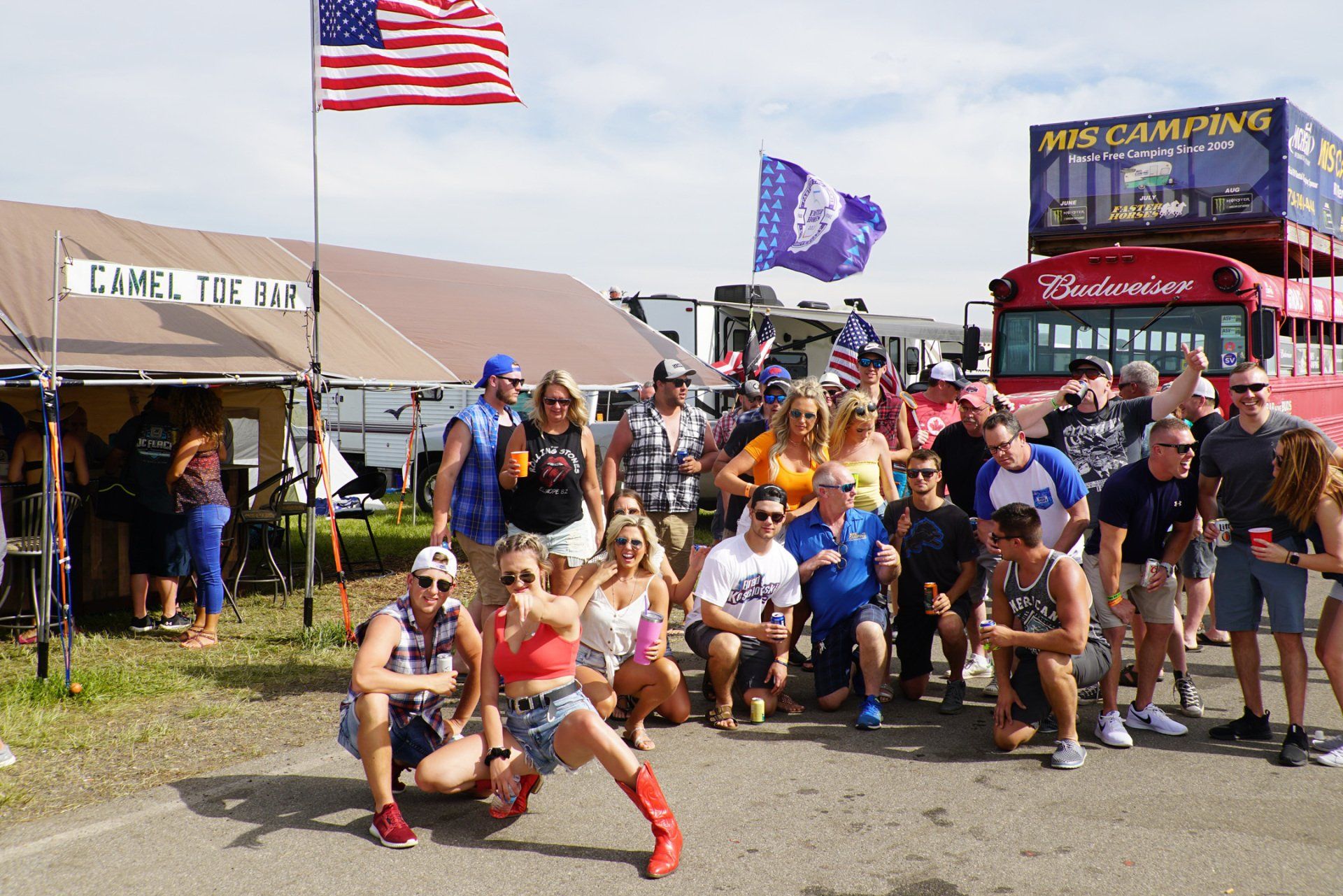 A group of people posing for a picture in front of a budweiser truck