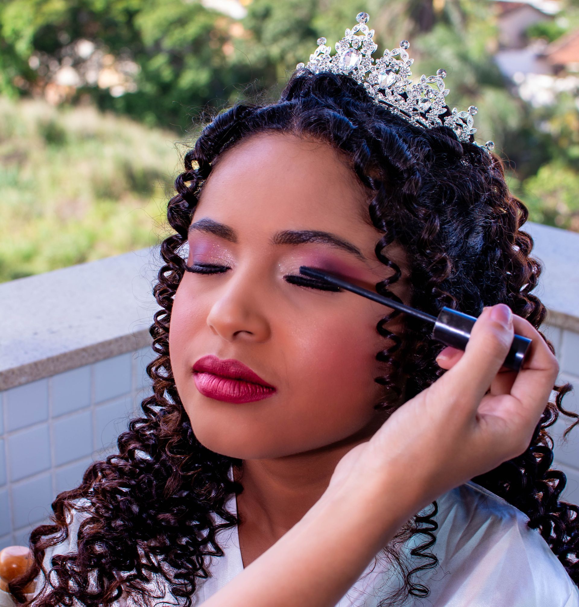 Pessoa usando tiara com rímel aplicado nos cílios, ao ar livre.