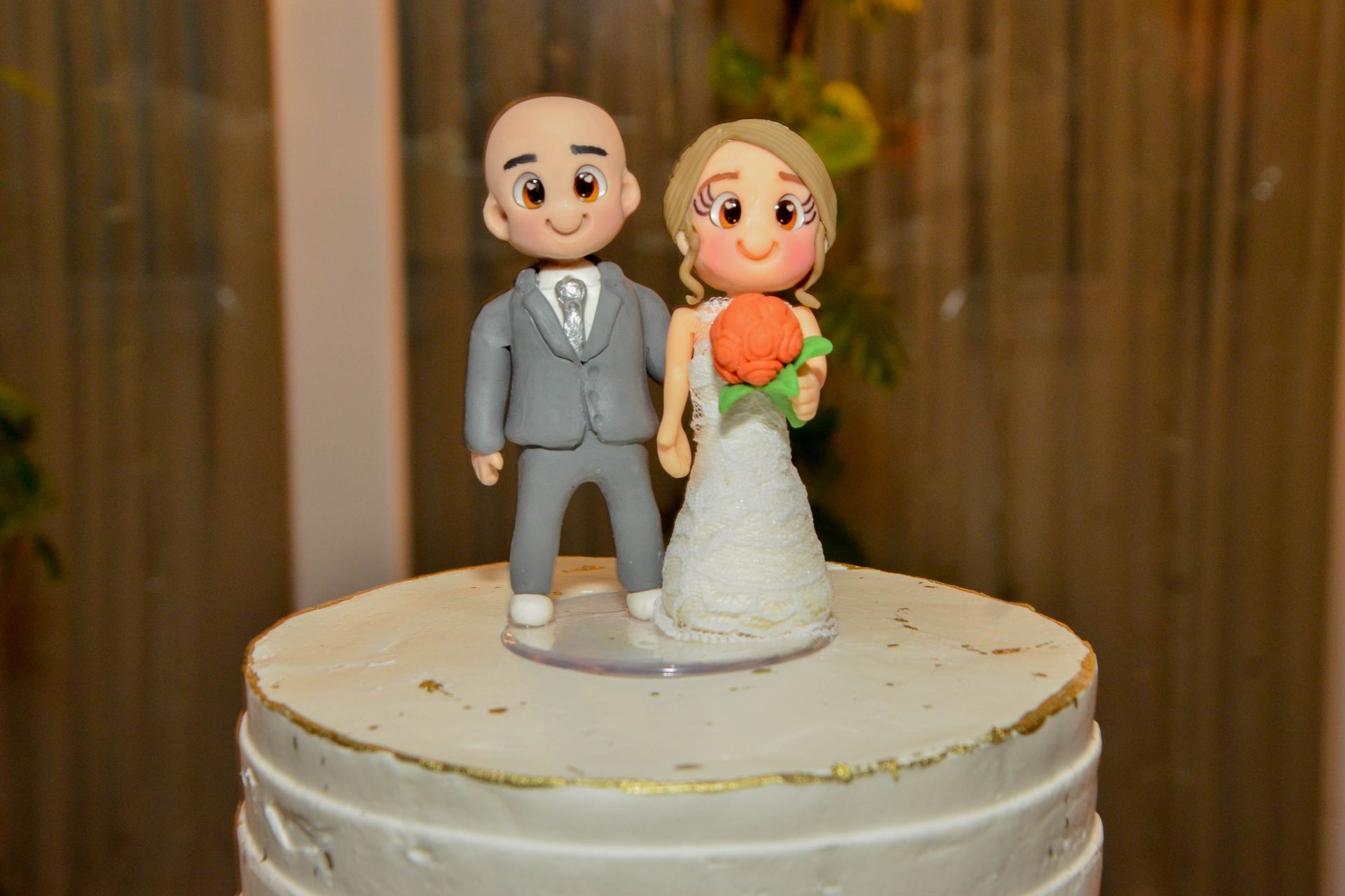 Bolo de casamento com topo de bolo com noivos em desenho animado.