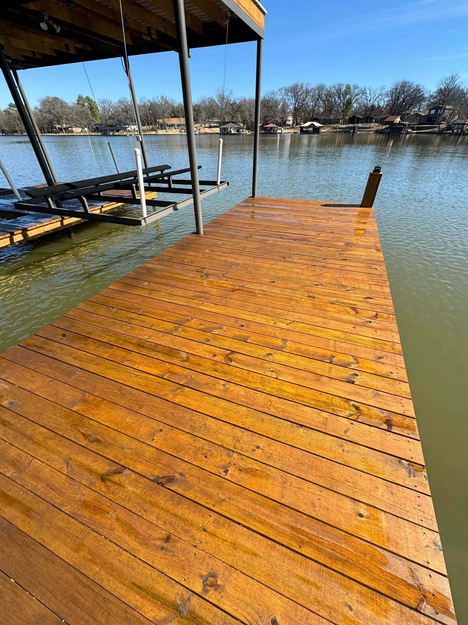 A wooden dock is sitting next to a body of water.
