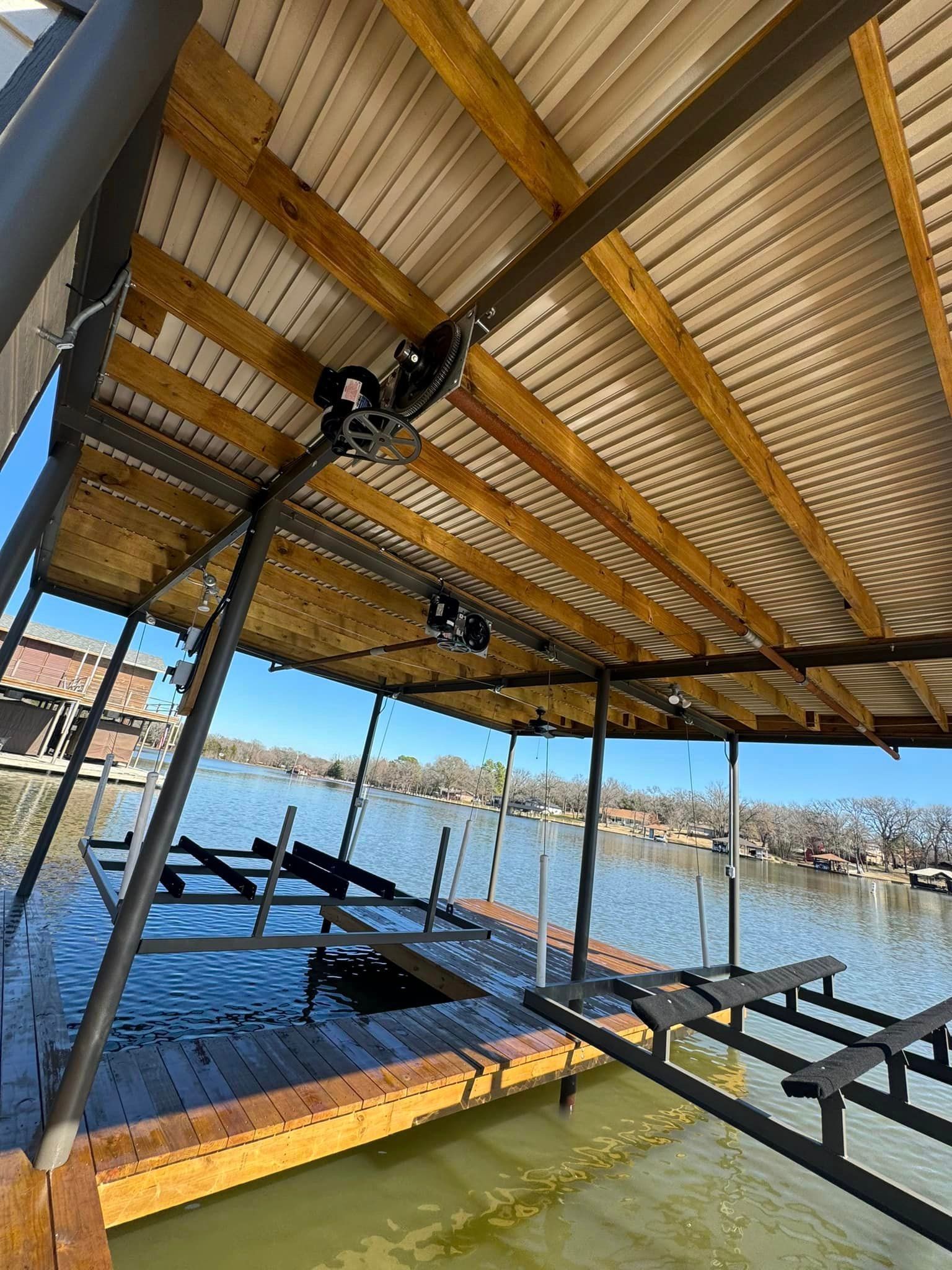 A dock with a wooden roof overlooking a body of water.
