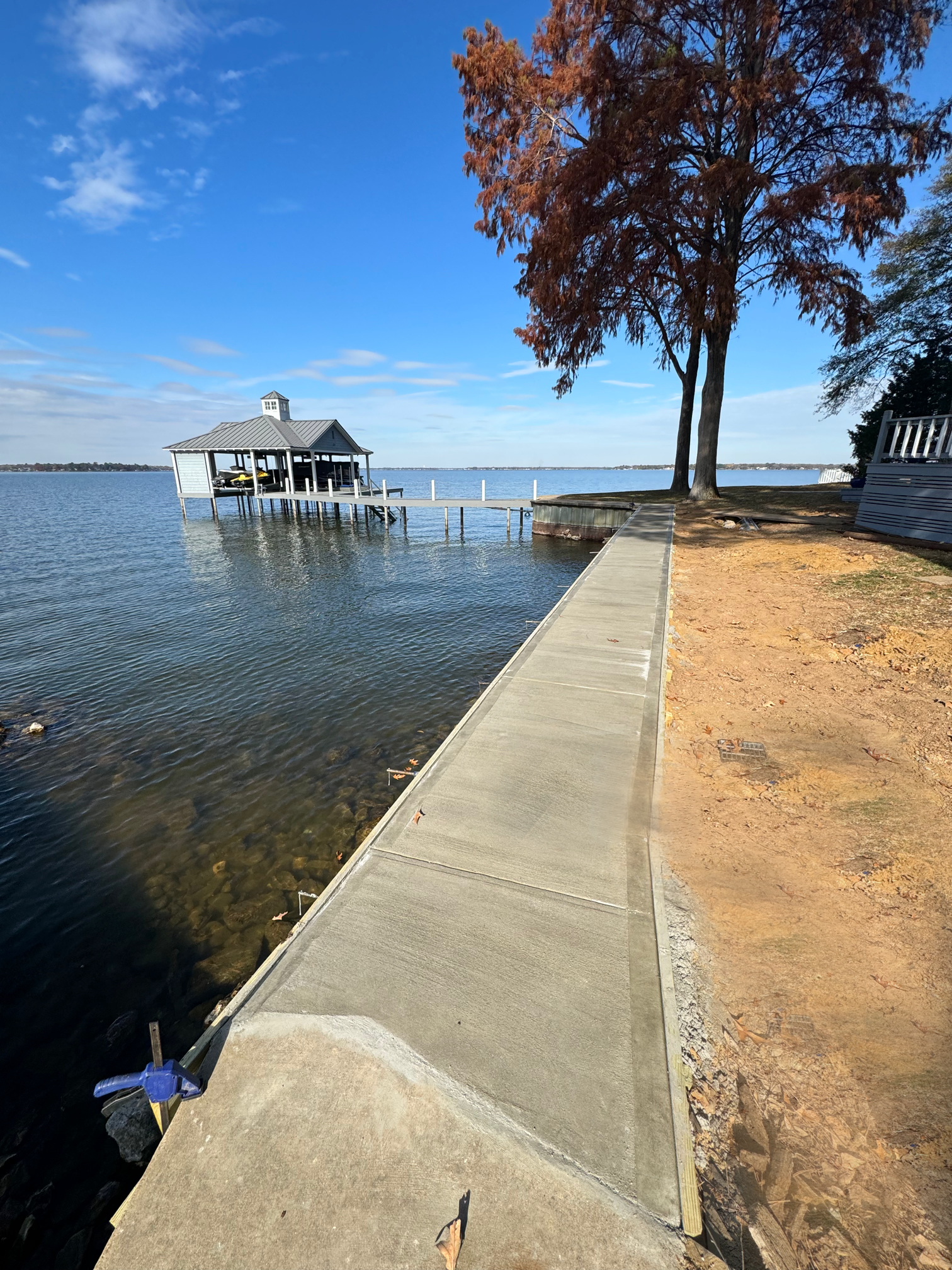A large body of water with a dock and a house in the background.
