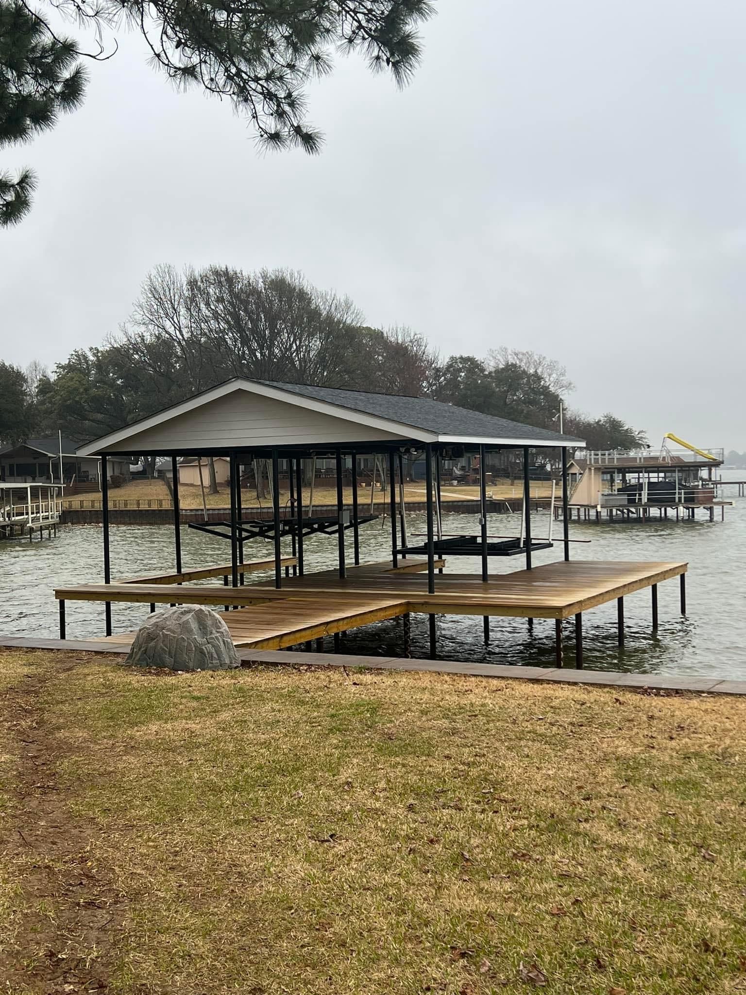 A dock with a house on top of it next to a body of water.