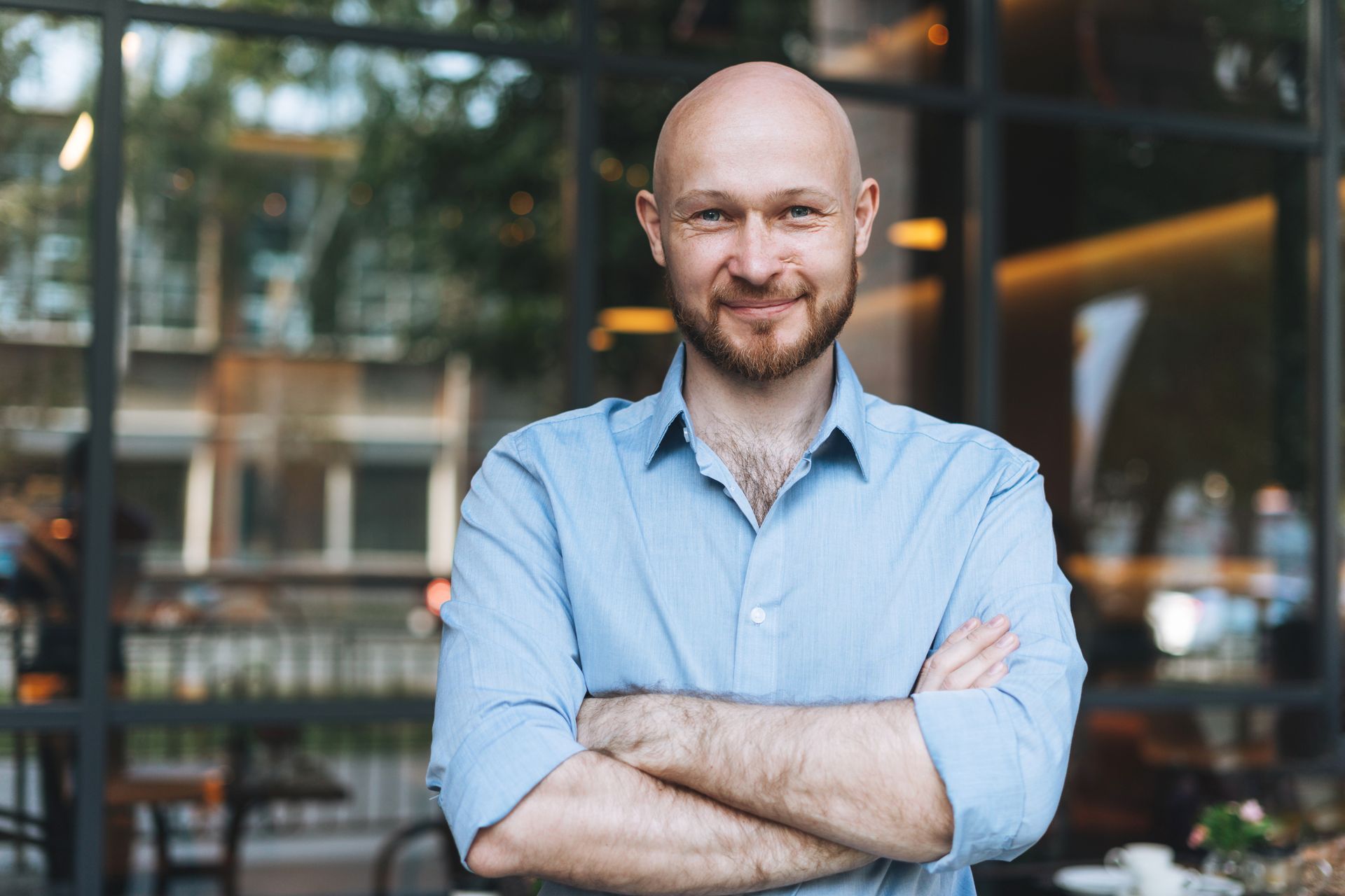 Man smiling standing in front of a bar