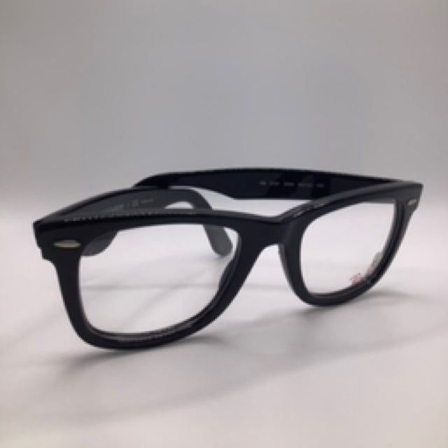 Black framed eyeglasses on a white surface, clear lenses.