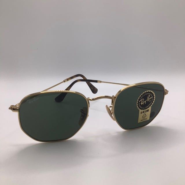 Gold-framed Ray-Ban sunglasses with green lenses, displayed on a white background.