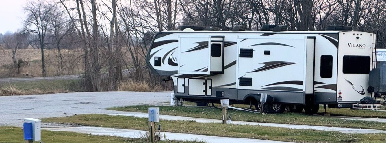 Spacious pull-through RV sites with full hookups at Downey Carriage House RV Park surrounded by trees