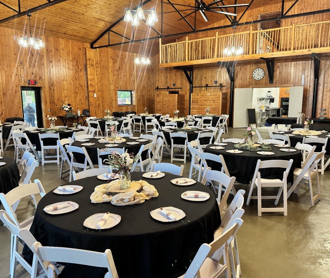 A large room with tables and chairs set up for a wedding reception.