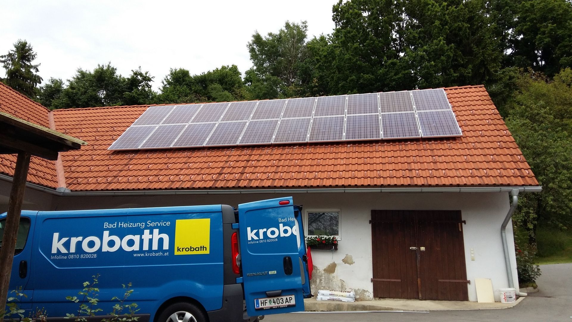 Ein blauer Krobath-Van steht vor einem Gebäude