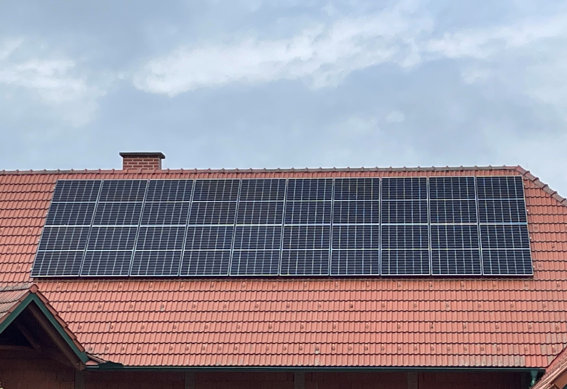 Auf dem Dach eines Hauses befinden sich viele Solarmodule.