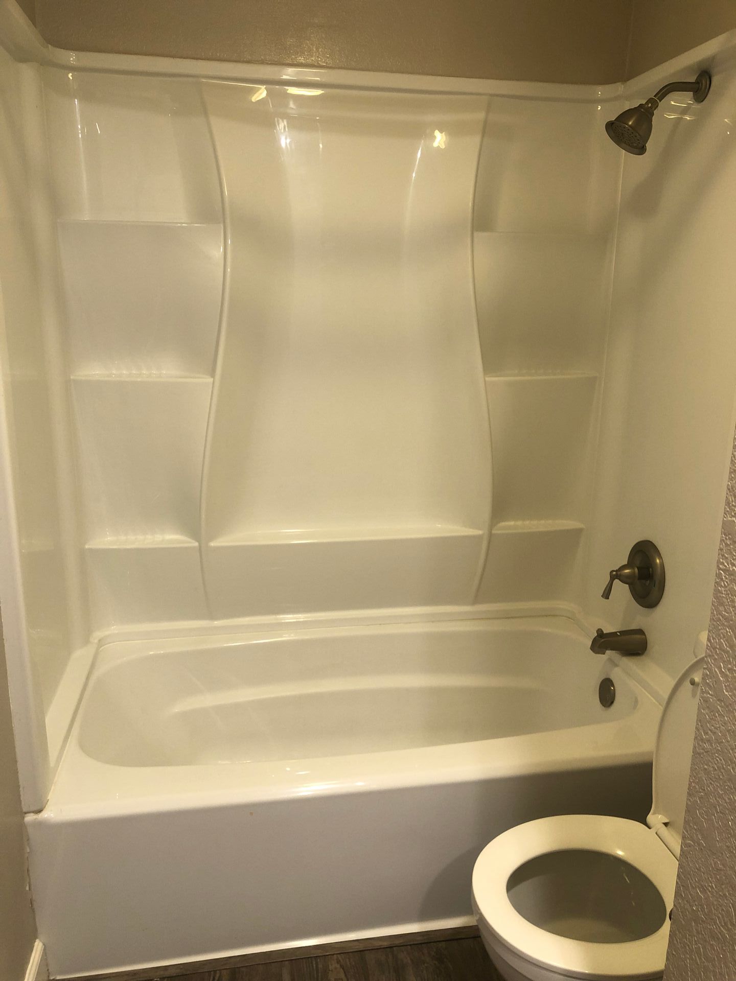 A bathroom with a bathtub , toilet and shower.