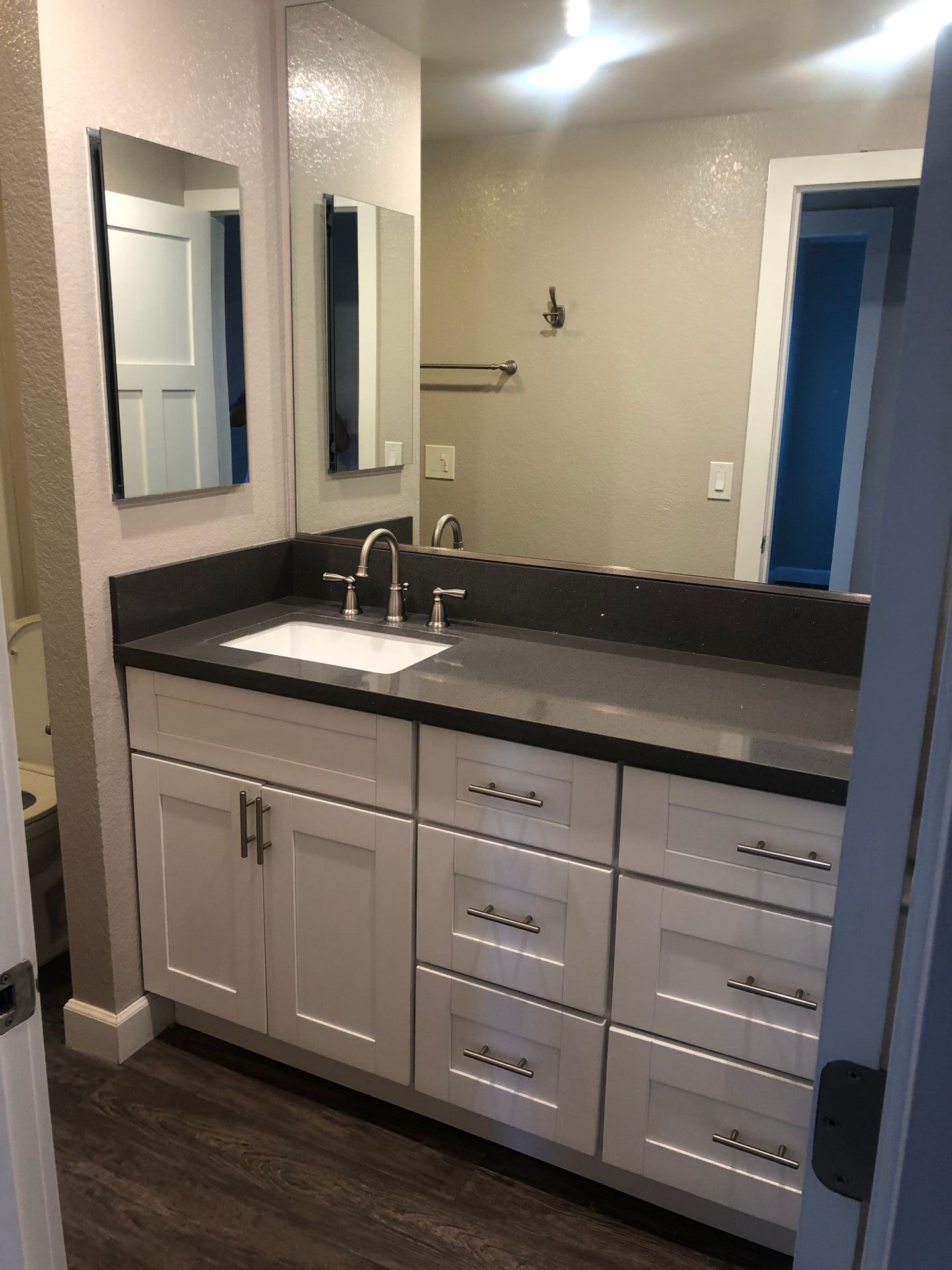 A bathroom with two sinks , two mirrors , and a large vanity.