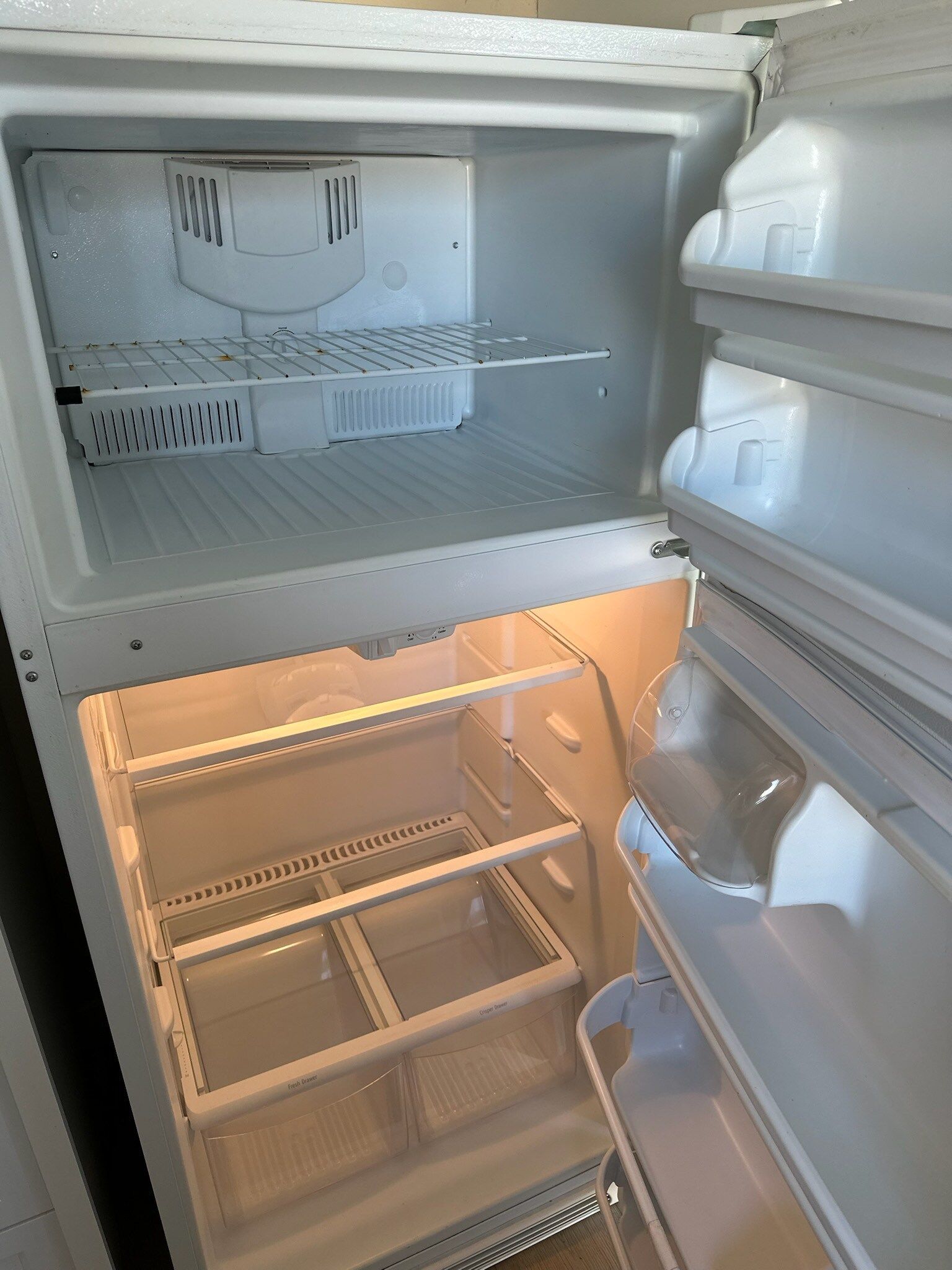 The inside of an empty refrigerator with the door open.