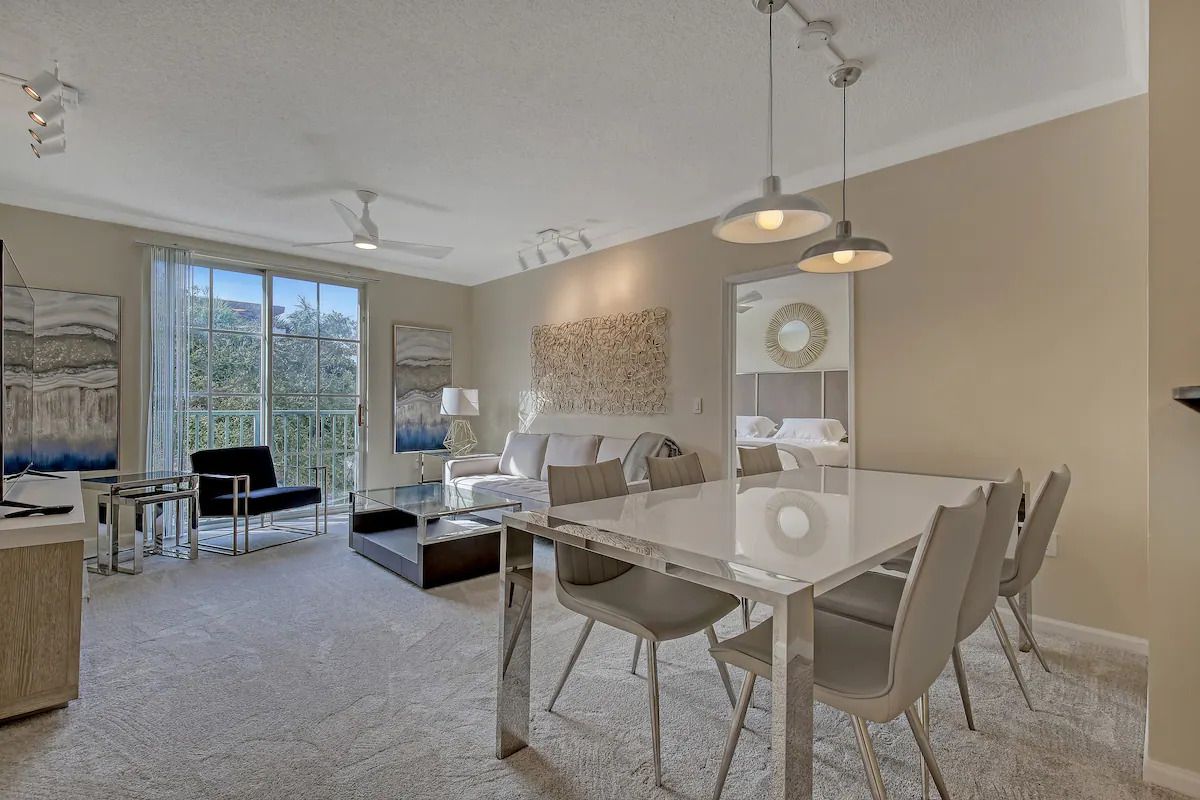 A living room with a dining table and chairs in it.