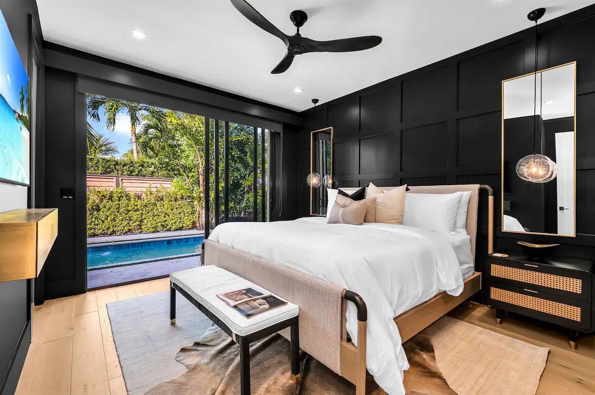 A bedroom with a large bed and a ceiling fan.