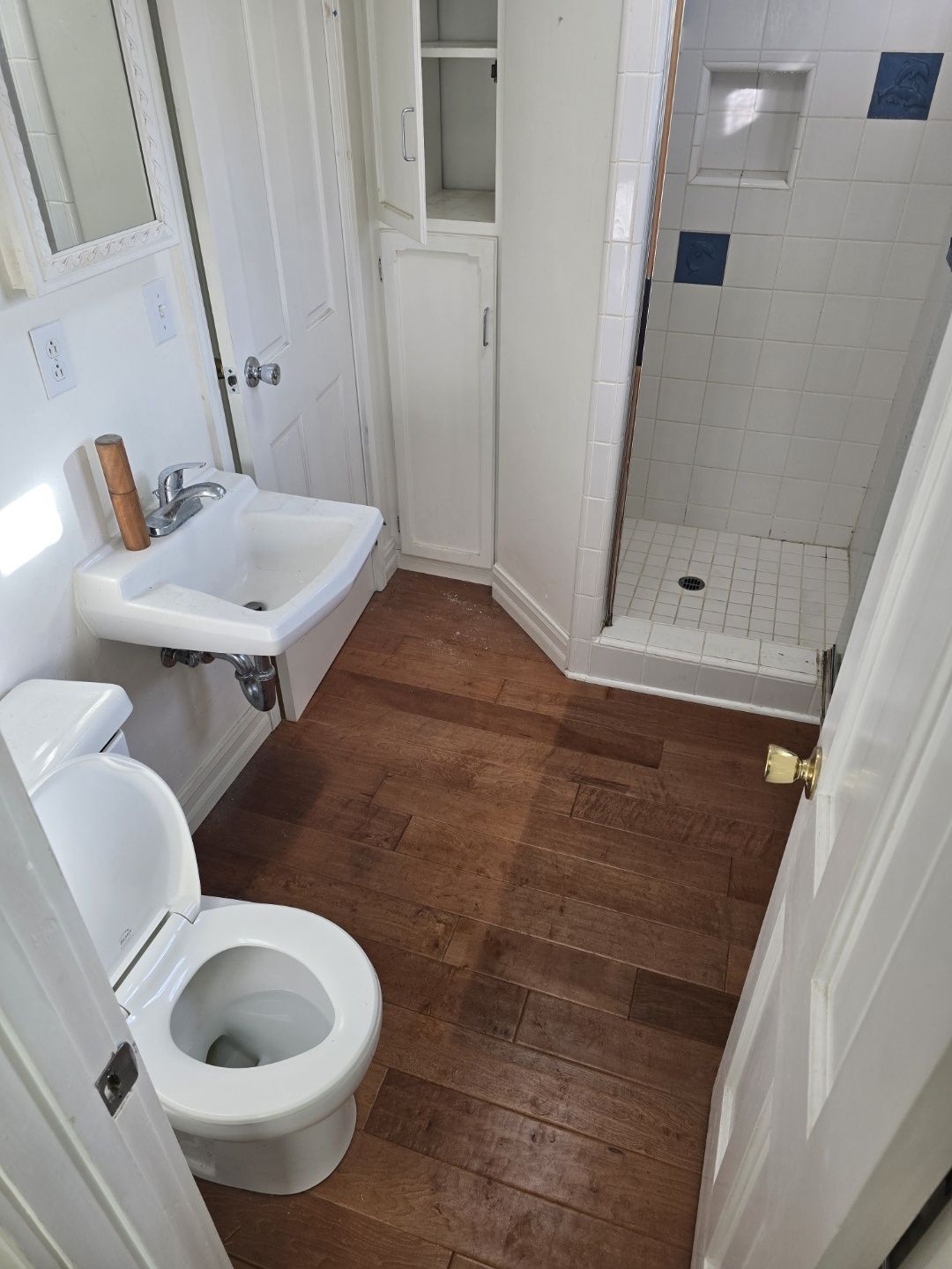 A bathroom with a toilet , sink and shower.