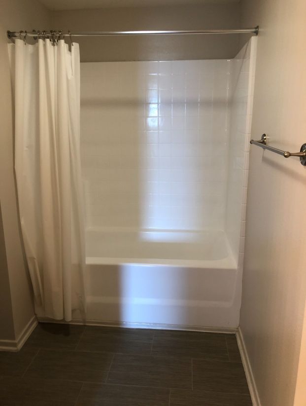 A bathroom with a bathtub and a shower curtain.