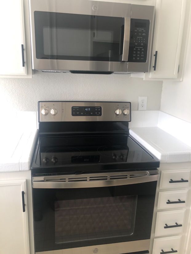 A kitchen with a stove top oven and a microwave