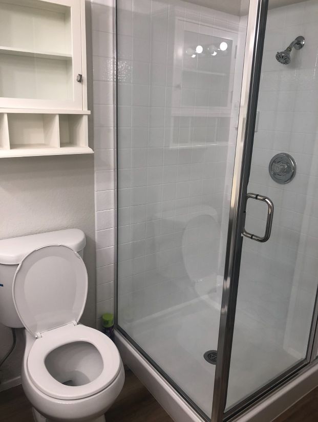 A bathroom with a toilet and a shower stall.