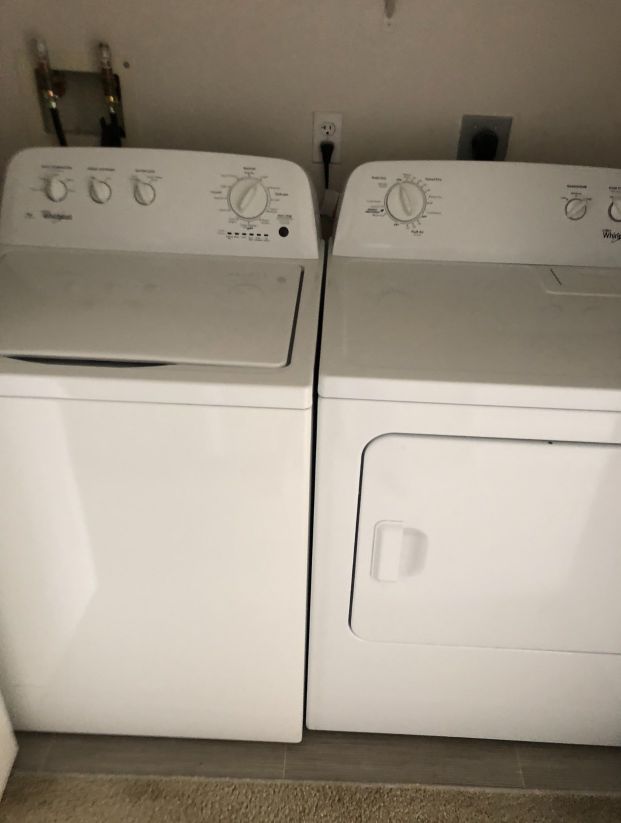 A washer and dryer are sitting next to each other in a laundry room.