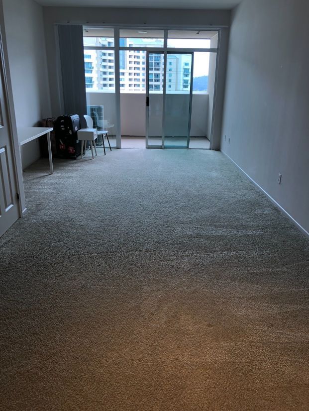 An empty living room with a sliding glass door and a balcony.