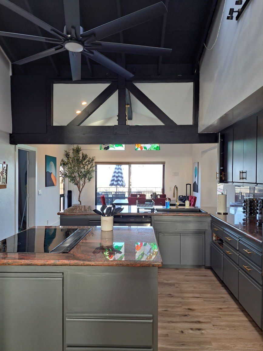 A kitchen with a large island and a ceiling fan
