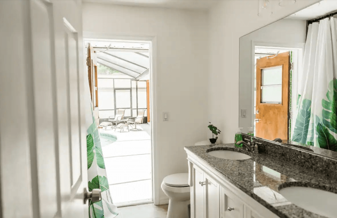 A bathroom with a toilet , sink , and mirror.