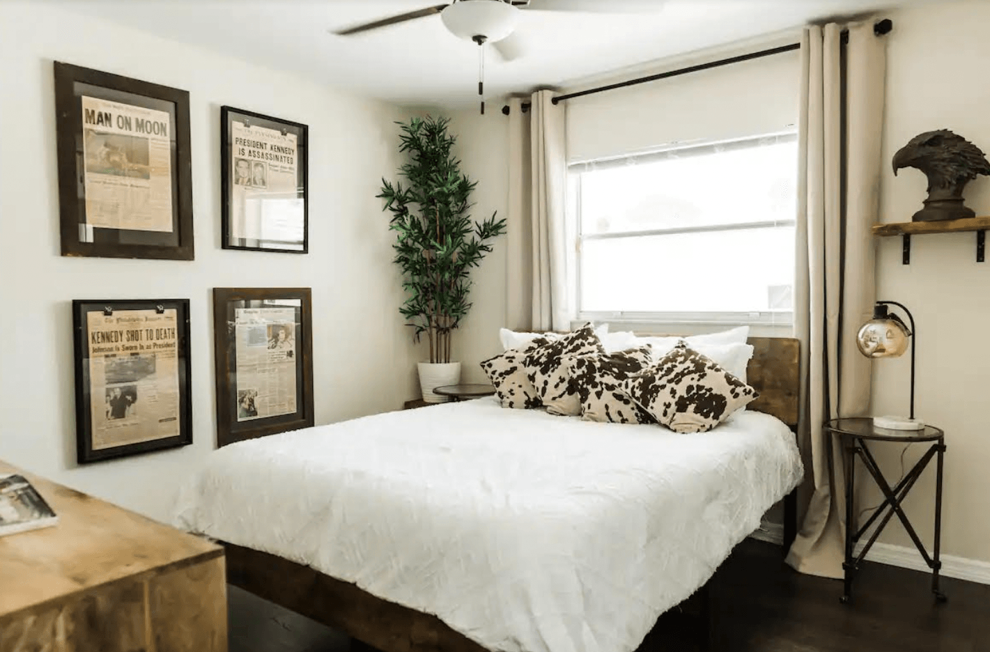 There is a bed in the middle of the room with a ceiling fan.