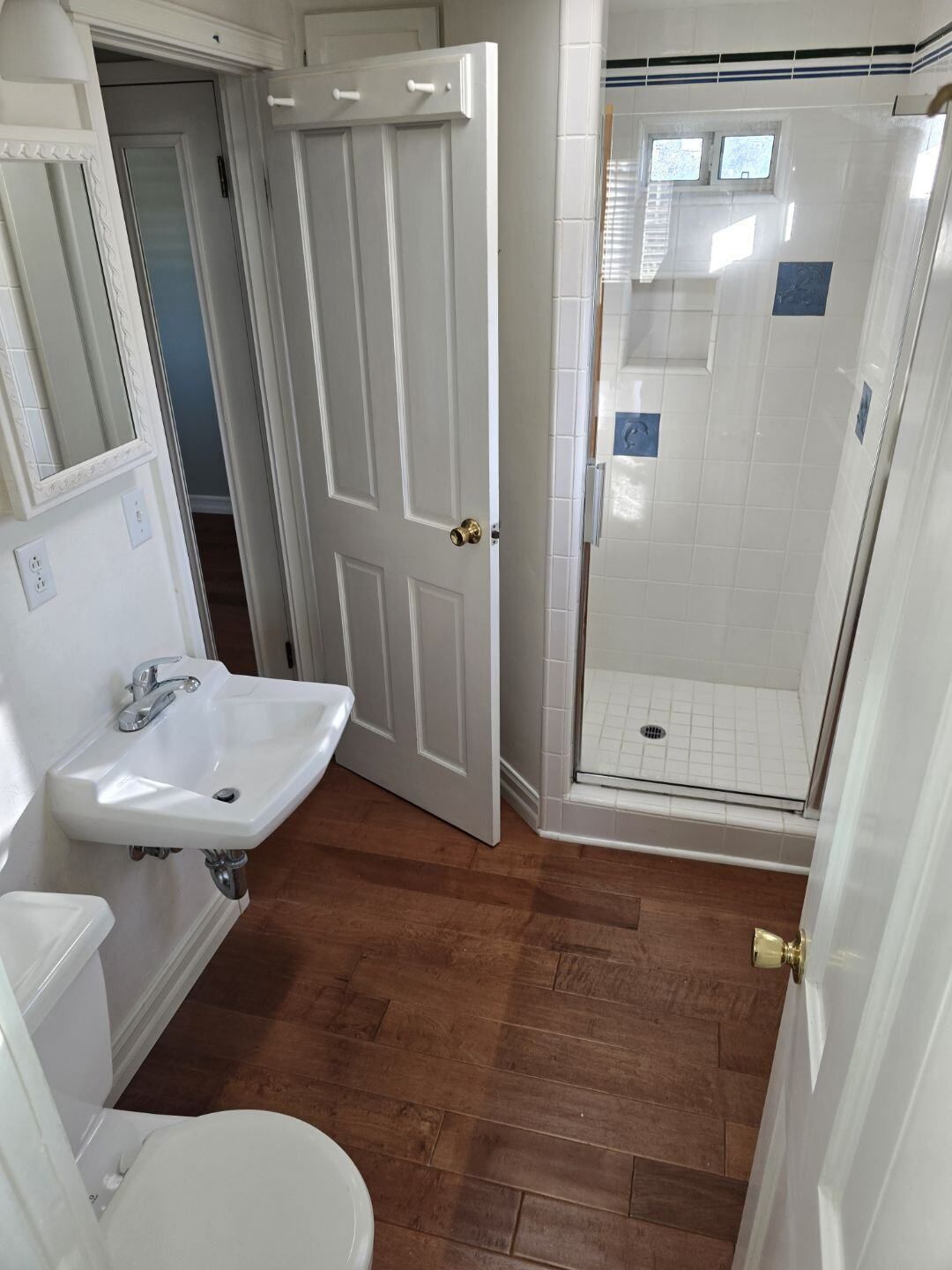 A bathroom with a sink , toilet and shower.