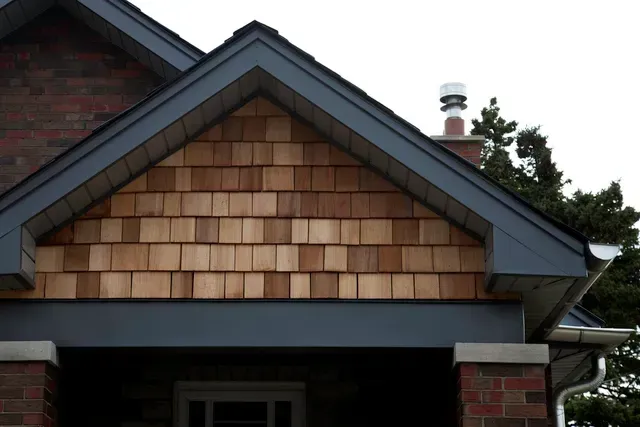 A brick house with a wooden shingle roof
