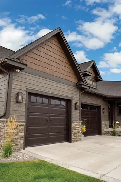 A large house with two garage doors and a driveway.