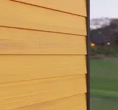 A close up of a yellow wooden siding on a house.
