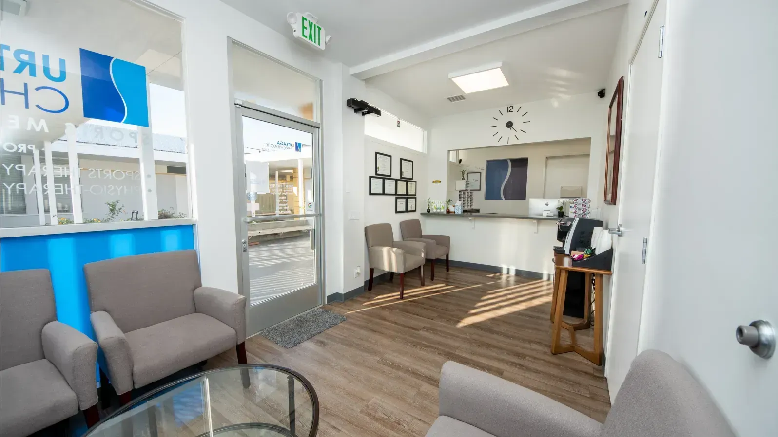 Reception area of a medical office with chairs, desk, and waiting area.