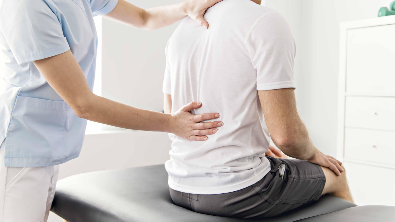 A person being treated by a healthcare worker for back pain.