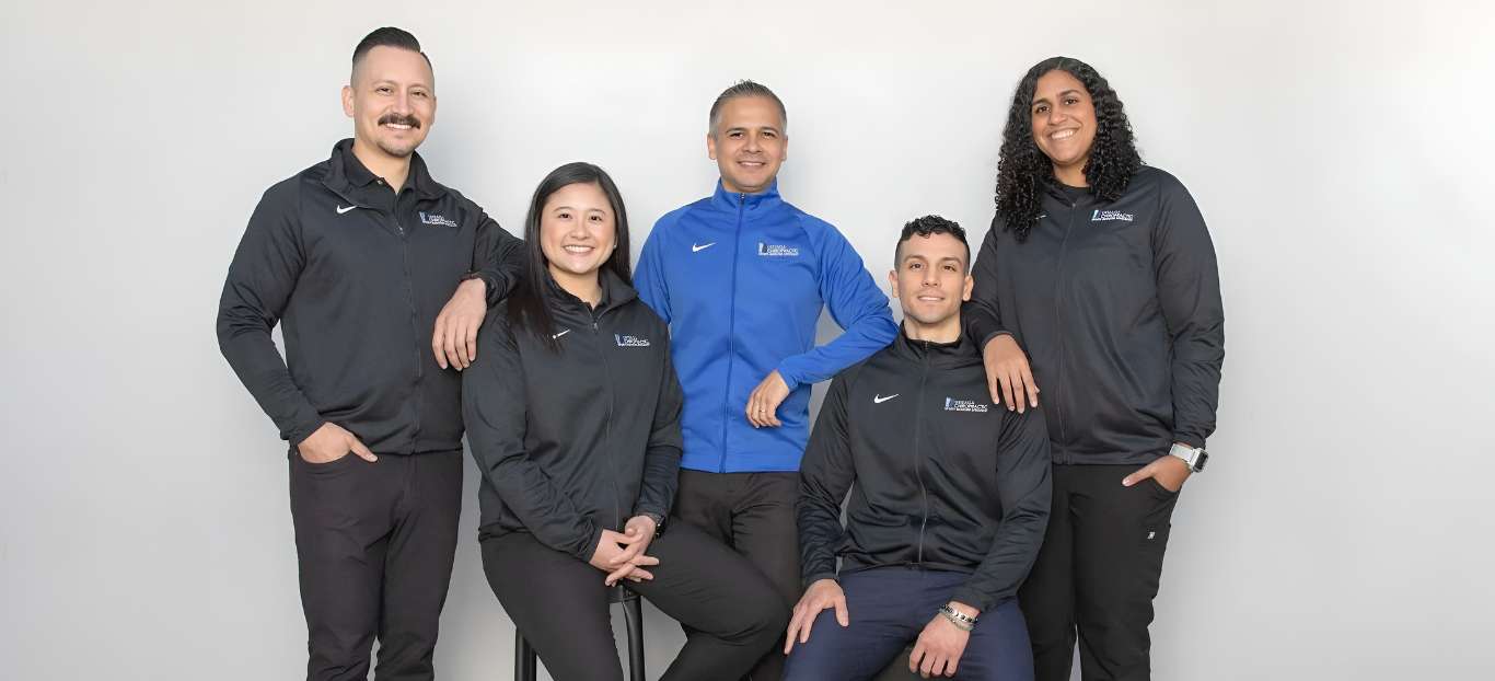 Five people in athletic wear pose in front of a gray background.