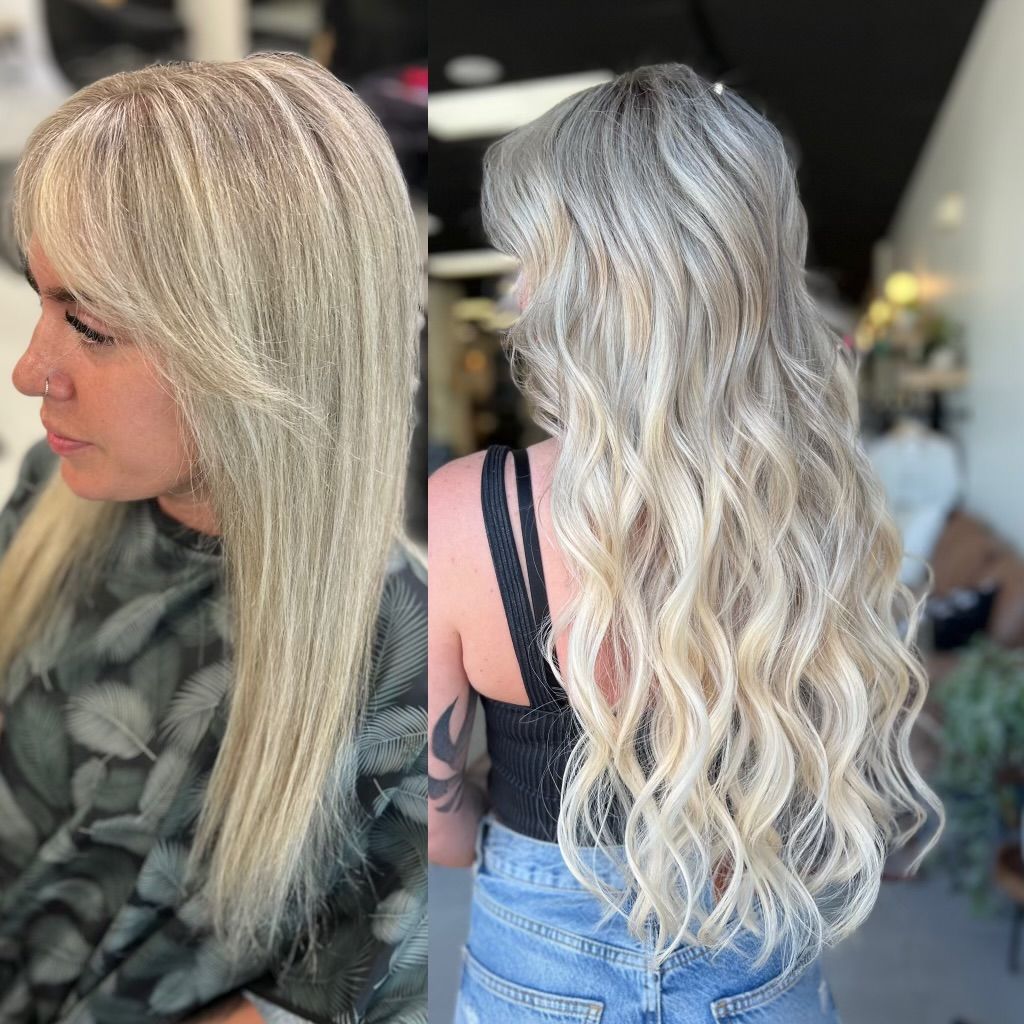 A woman with long blonde hair is sitting in a chair in a salon.