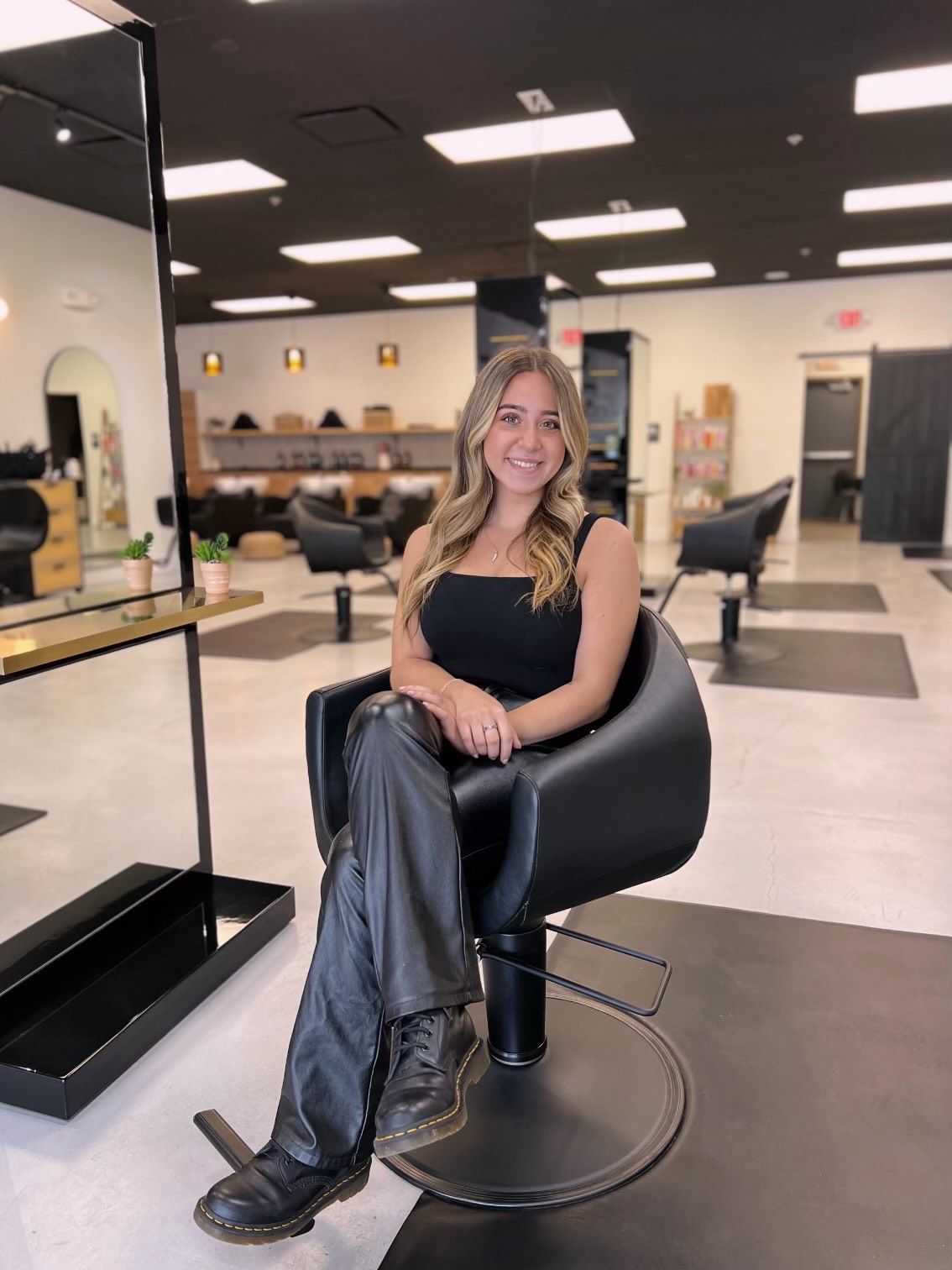 A woman is sitting in a chair in a salon.