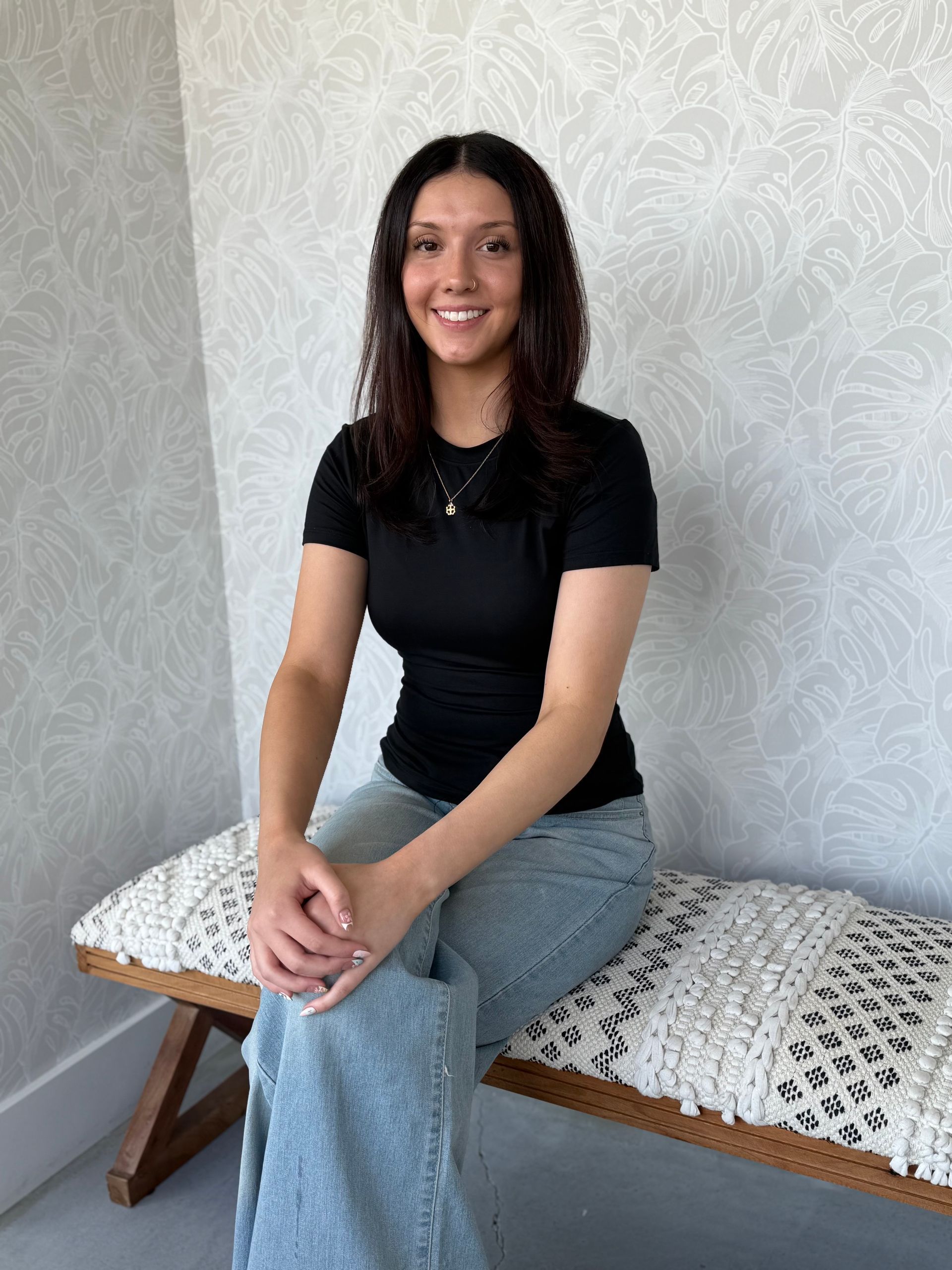 A woman is sitting in a chair in a hair salon.