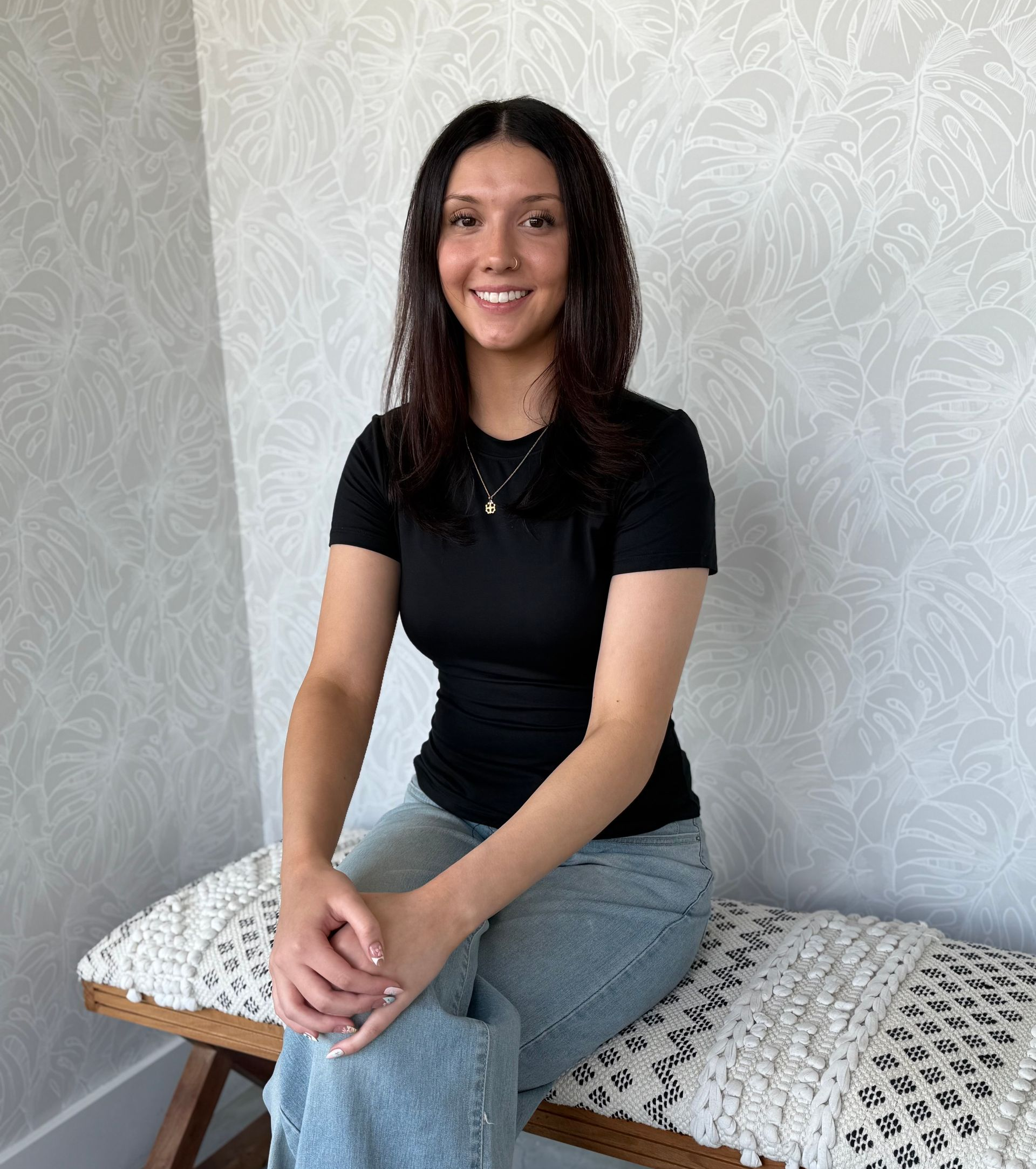 A woman is sitting in a chair in a hair salon