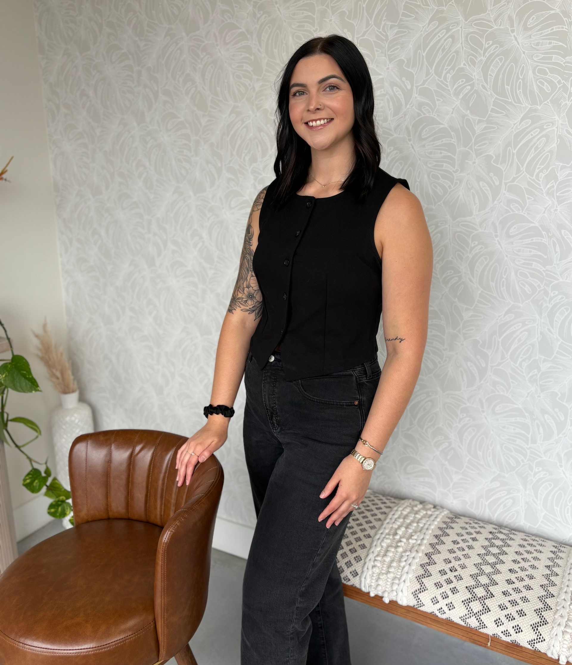 A woman is sitting on a wooden bench and smiling