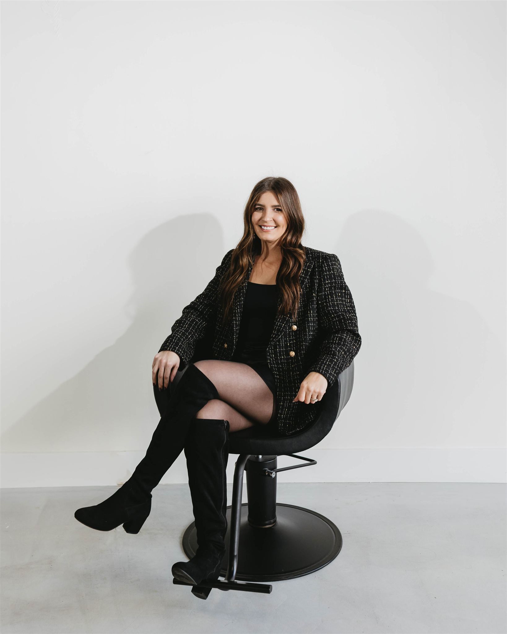 A woman is sitting in a chair in a hair salon.