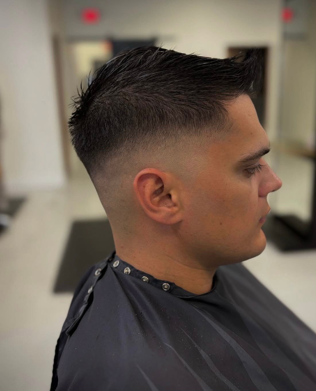 A man is getting his hair cut at a barber shop.