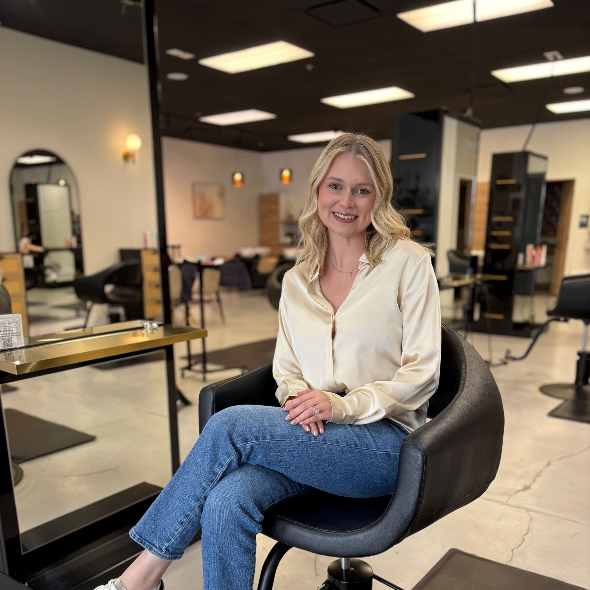A woman is sitting on a bench with her legs crossed