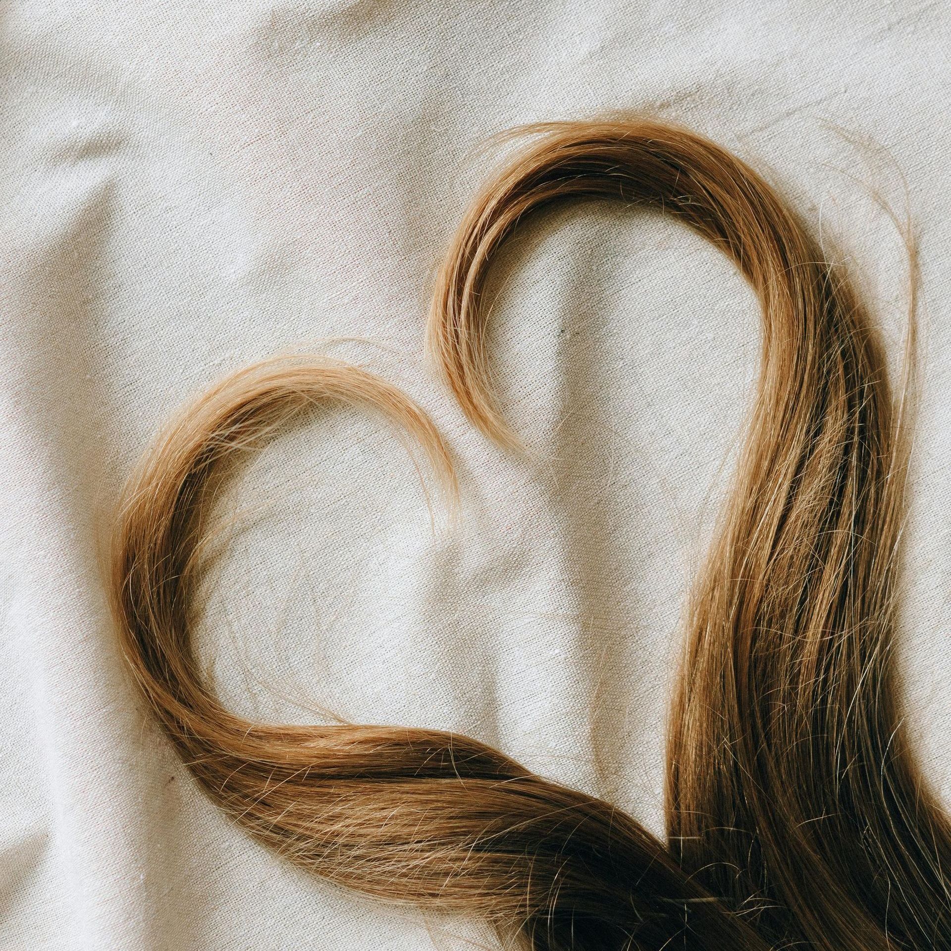 A close up of a woman 's hair in the shape of a heart