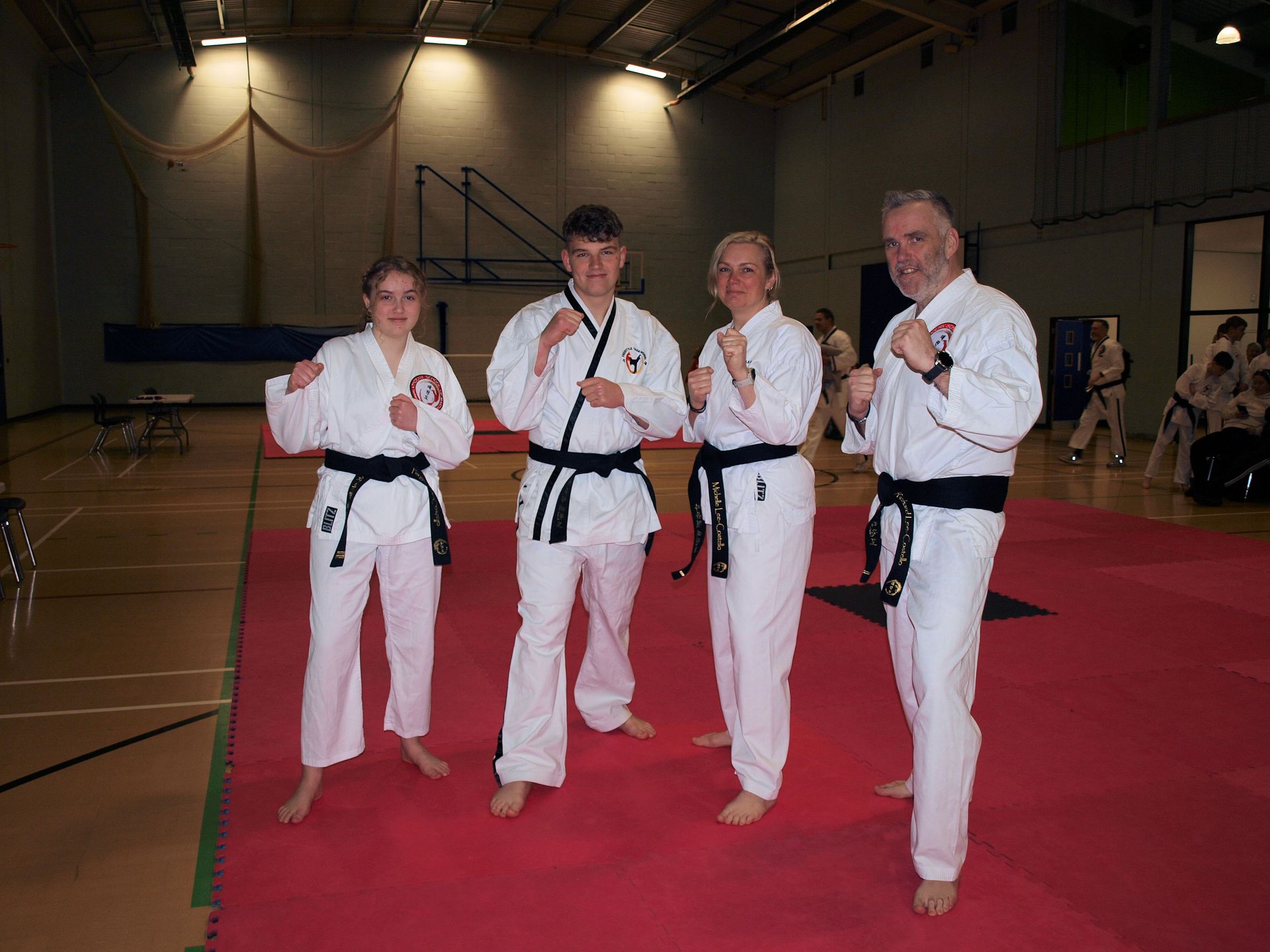 A group of people in Taekwondo uniforms are posing for a picture