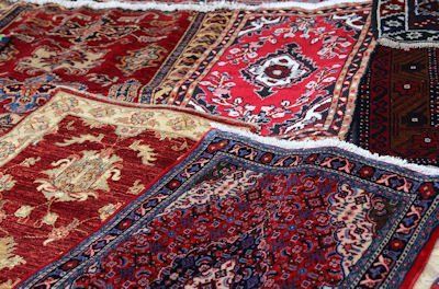 A bunch of rugs are stacked on top of each other on a table.
