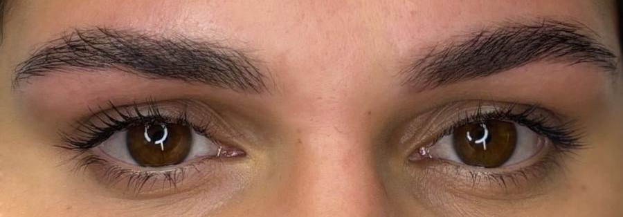 Primo piano degli occhi di una persona, che mostra sopracciglia scure, occhi marroni con lunghe ciglia.